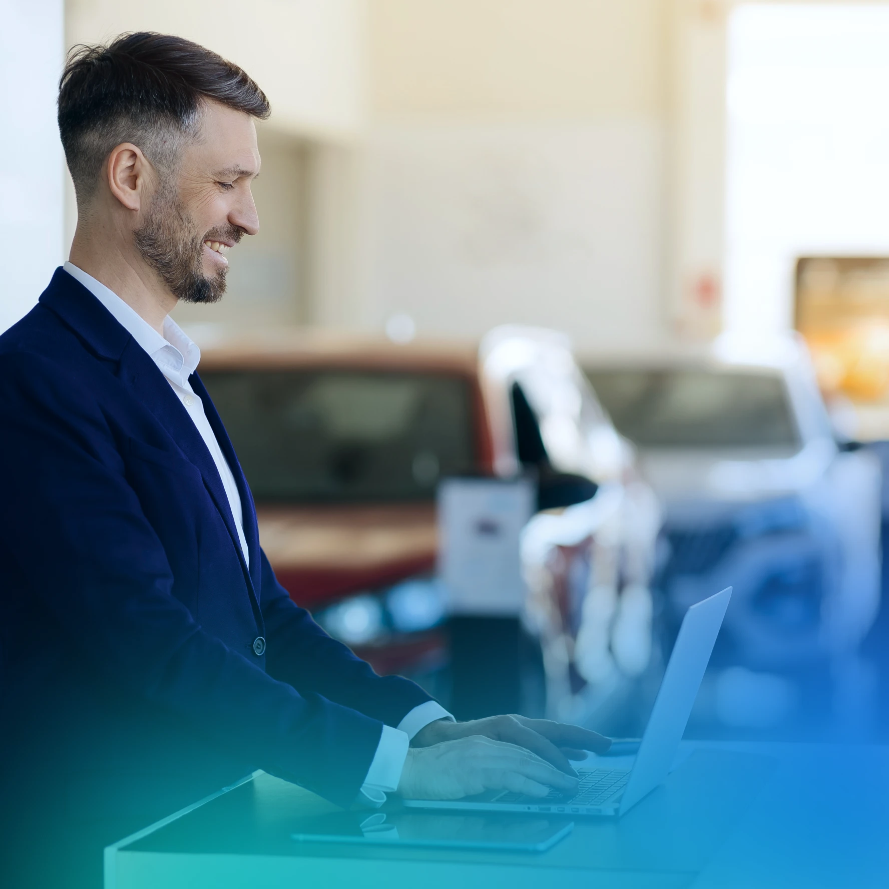 Man on a laptop in a car dealership