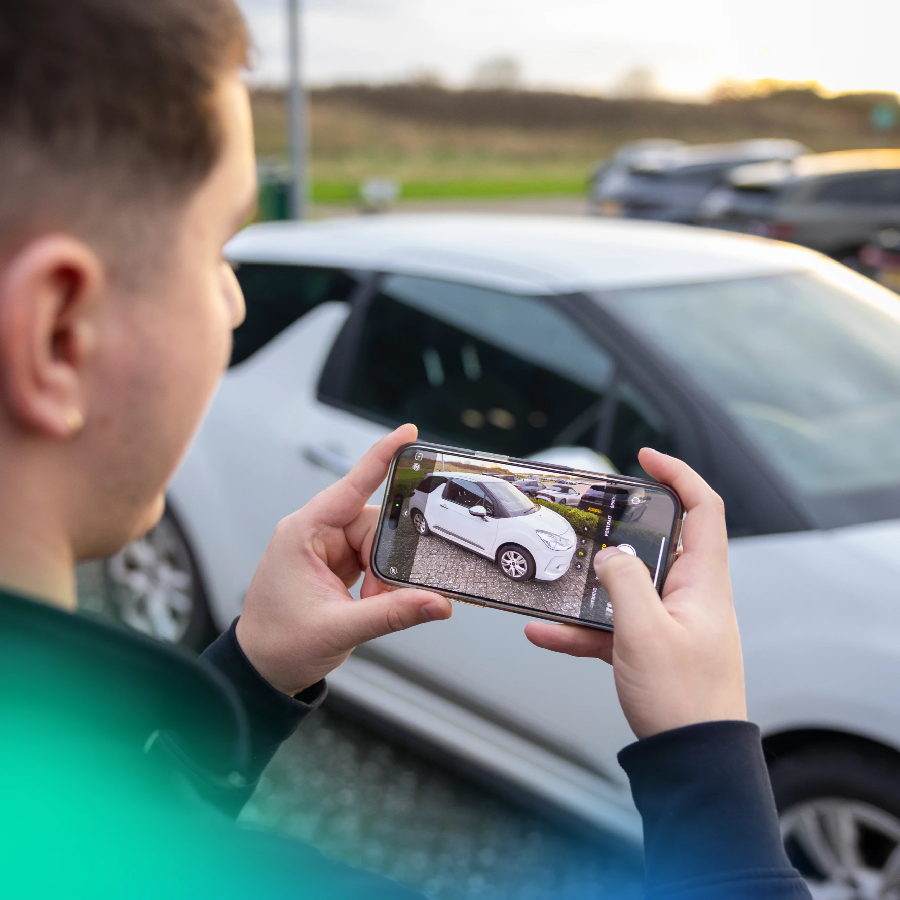Man taking a picture of his car on his phone