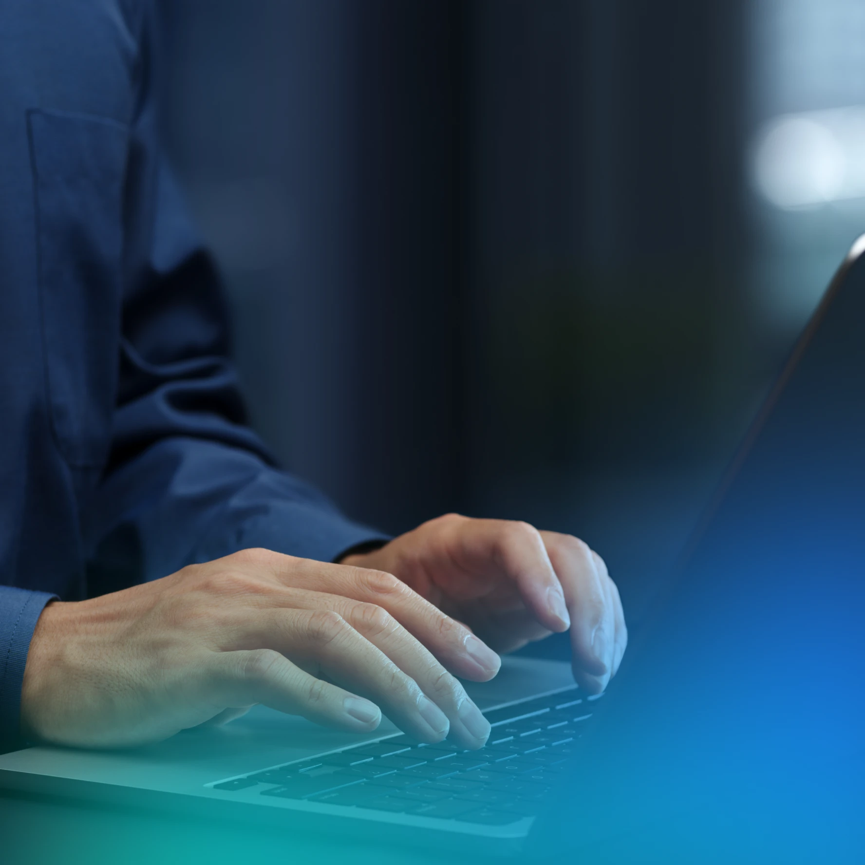 Hands typing on a laptop