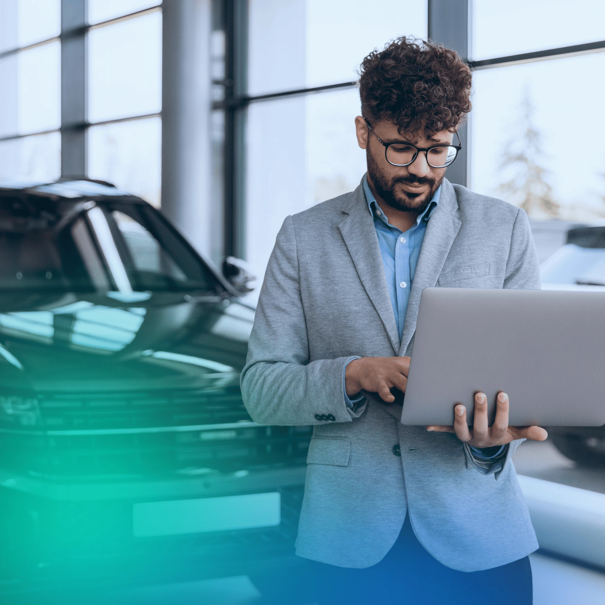 Man at a car dealership on his laptop
