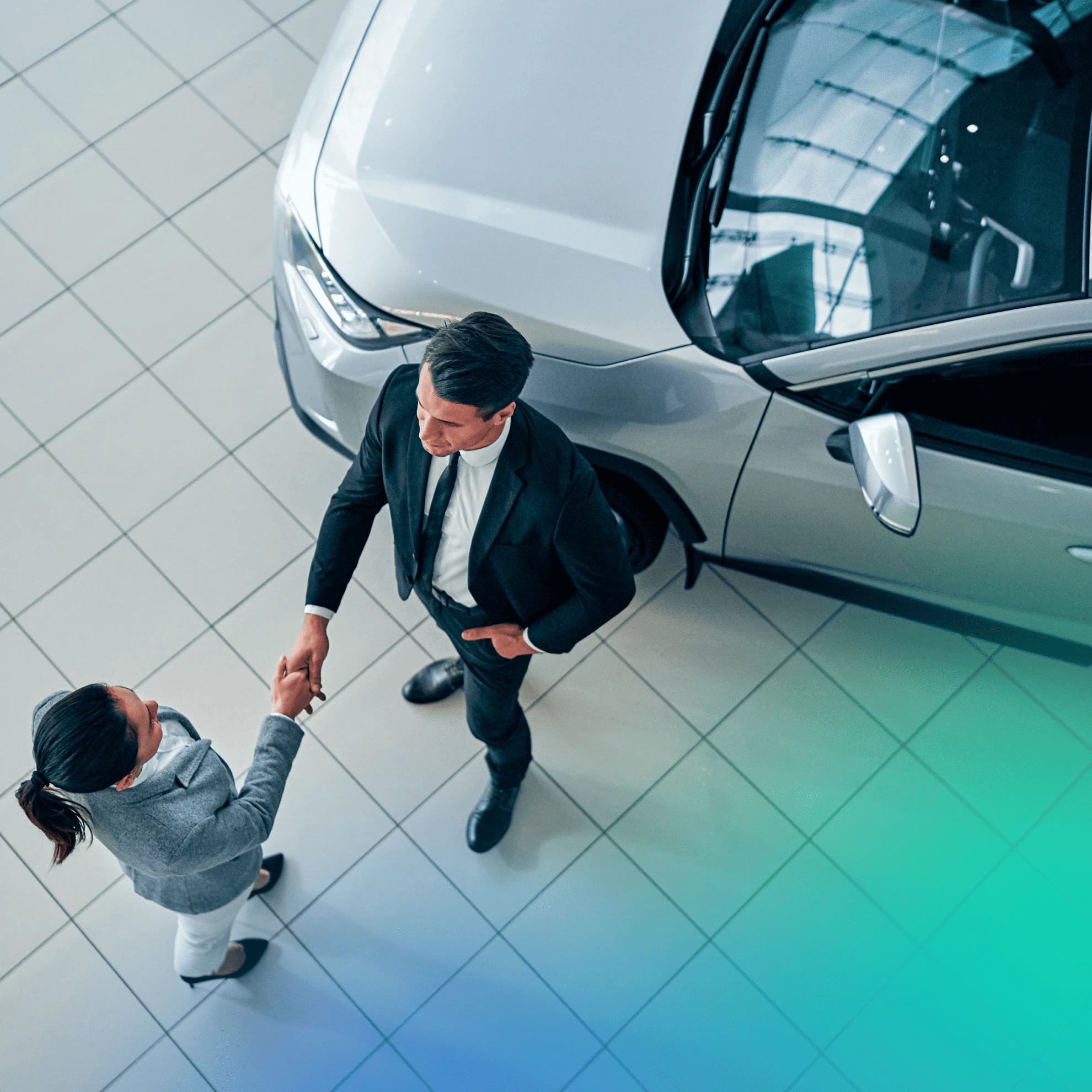 Two people shaking hands at a car dealership