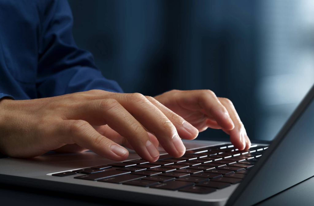 hands typing on a laptop